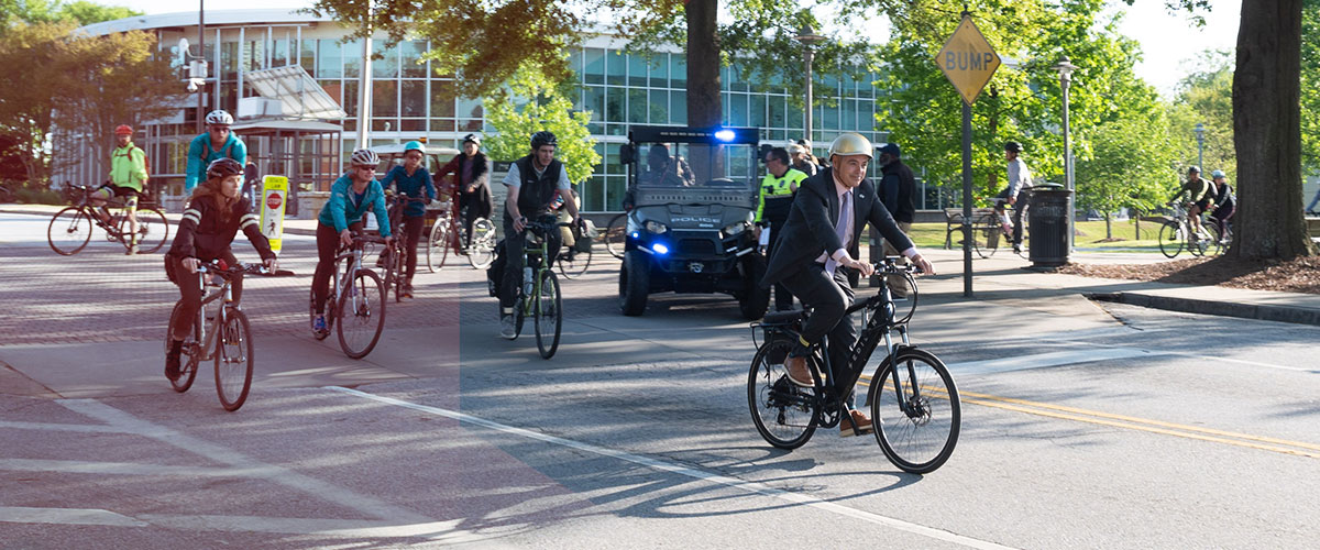President Cabrera riding on bicycle with other students and campus police officers.